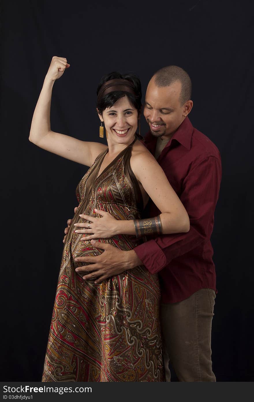 Portrait of young cheerful hispanic couple specting a child, isolated on black. Portrait of young cheerful hispanic couple specting a child, isolated on black