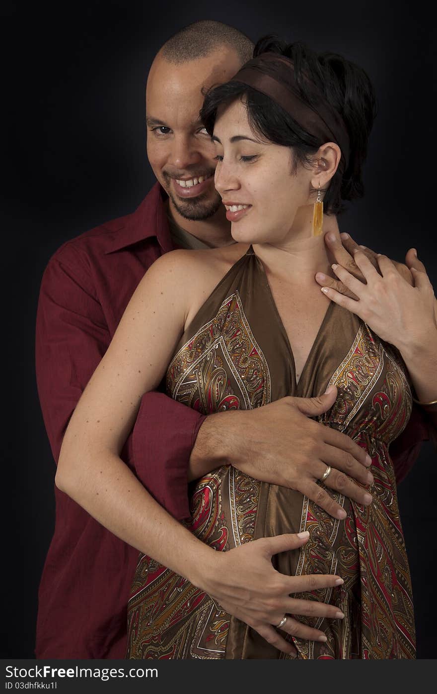 Portrait of young cheerful hispanic couple specting a child, isolated on black. Portrait of young cheerful hispanic couple specting a child, isolated on black