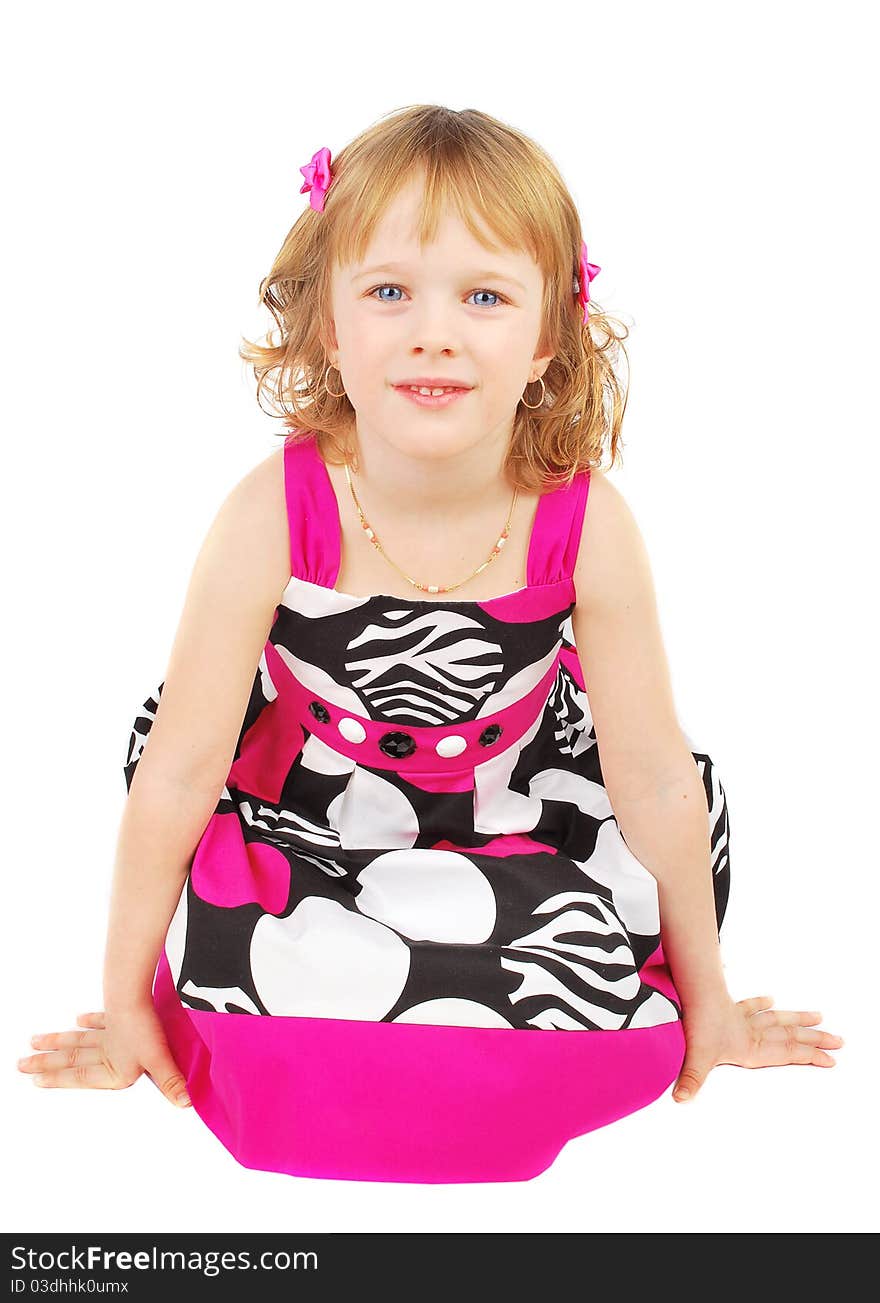 Pretty little girl wearing a pink and black summer dress smiling sitting on the floor isolated on white background. Pretty little girl wearing a pink and black summer dress smiling sitting on the floor isolated on white background.