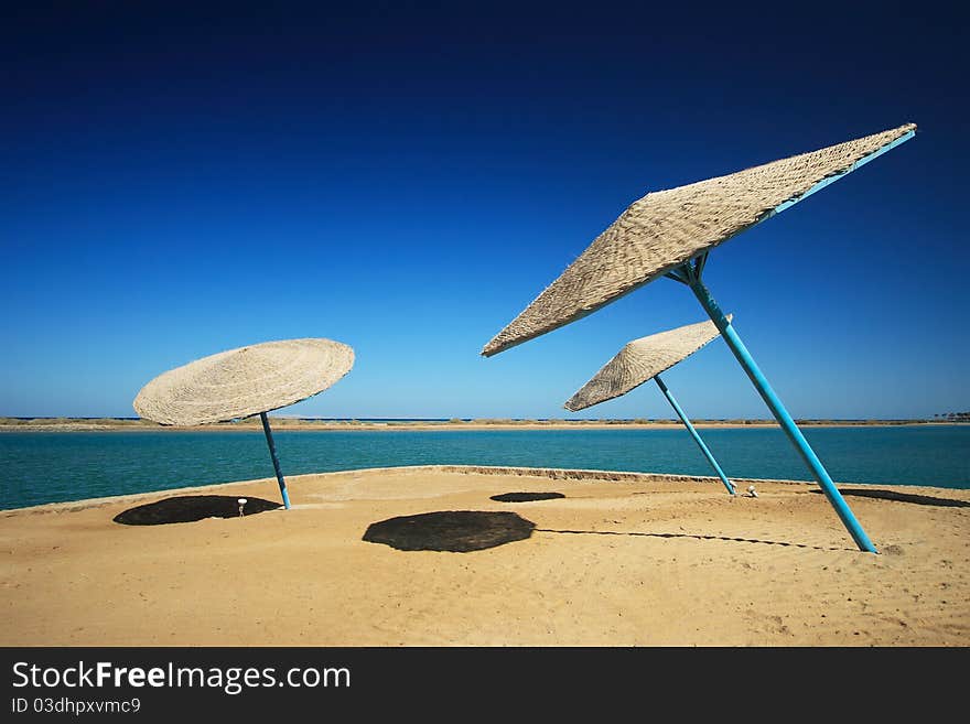 Wicker Beach Umbrella with wicker wind breaks.