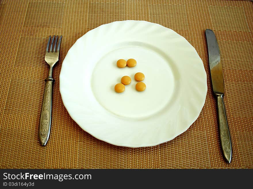 Pills on the white plate for dinner