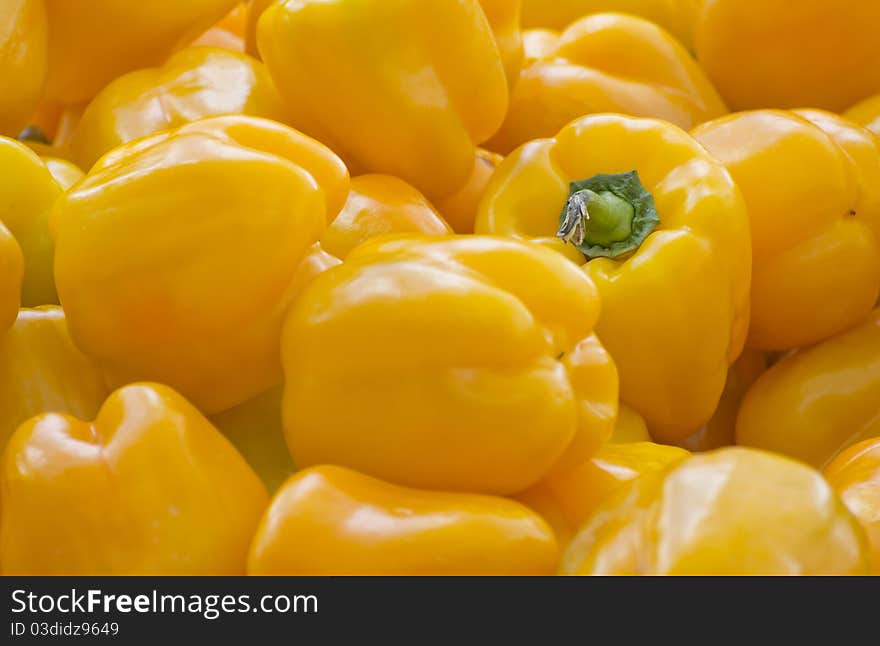 A pile of yellow peppers under natural light.