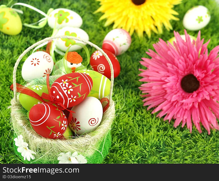 Spring flowers and colorful Easter eggs in a basket