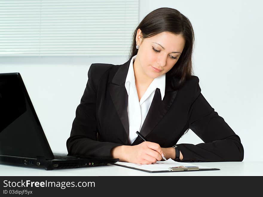 Beautiful girl in a business suit working in the office. Beautiful girl in a business suit working in the office