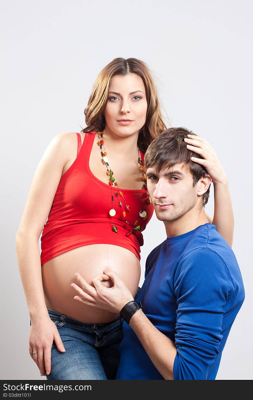 Man show ok sign on pregnant belly of his wife