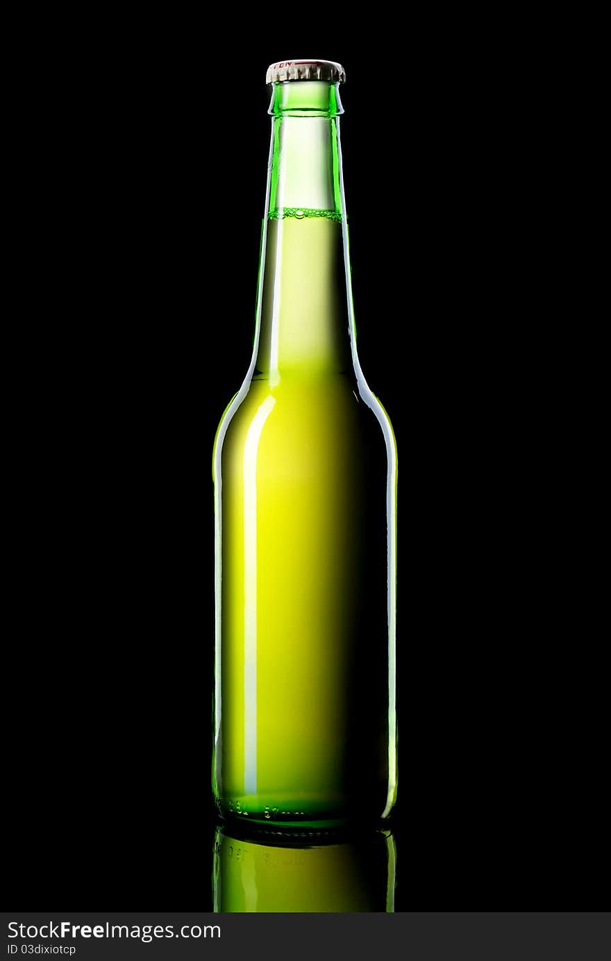 A green bottle of beer on a black background