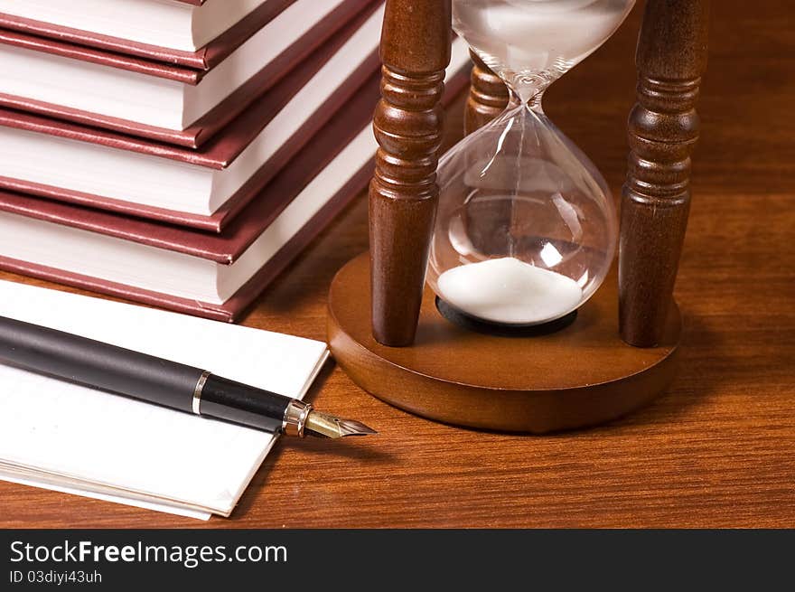 Hourglasses And Book On A Wooden Table