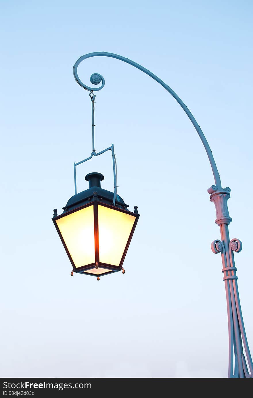 Lighting retro lamppost on the blue night sky background