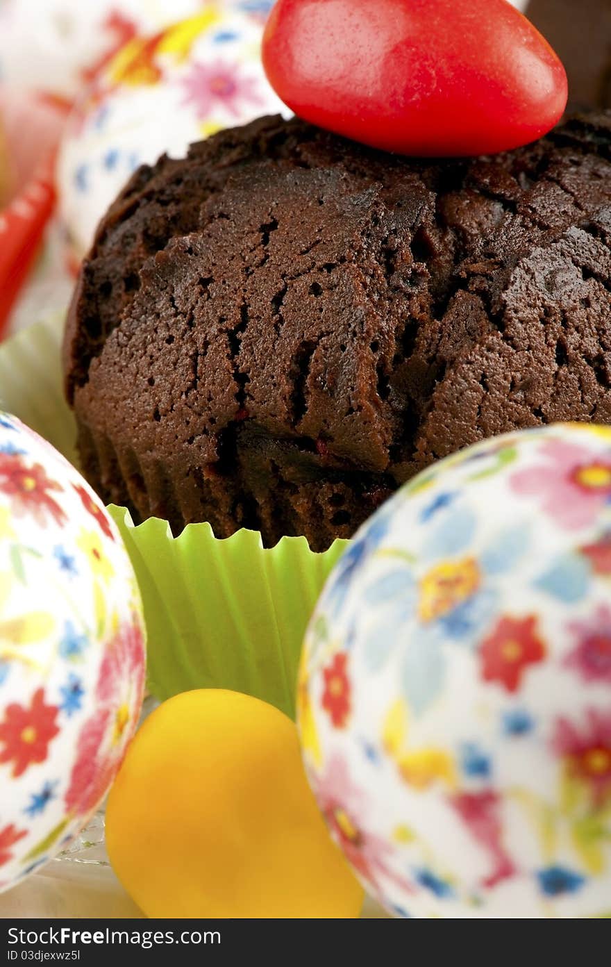 Chocolate muffin decorated with easter eggs closeup. Chocolate muffin decorated with easter eggs closeup