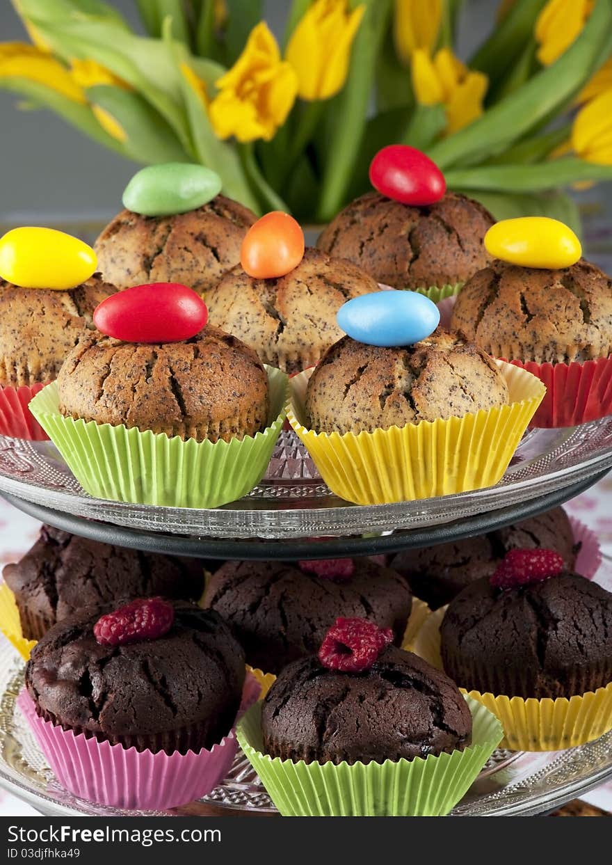 Muffins decorated with easter eggs and tulips in the background