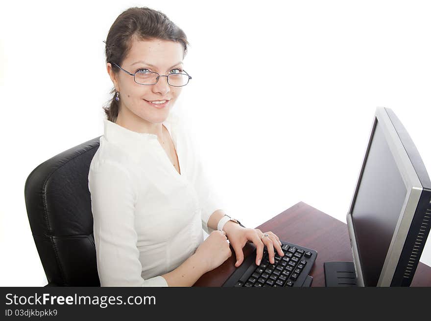 Smiling businesswoman sitting at her desk with TFT screen . landscape orientation. Smiling businesswoman sitting at her desk with TFT screen . landscape orientation