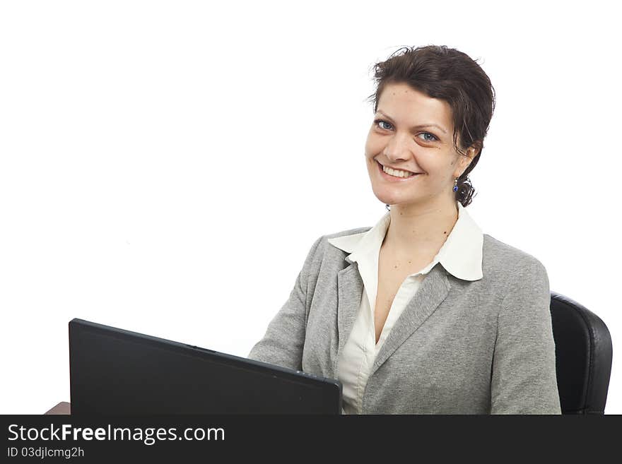 Businesswoman smiling at her desk with laptop, landscape orientation. Businesswoman smiling at her desk with laptop, landscape orientation