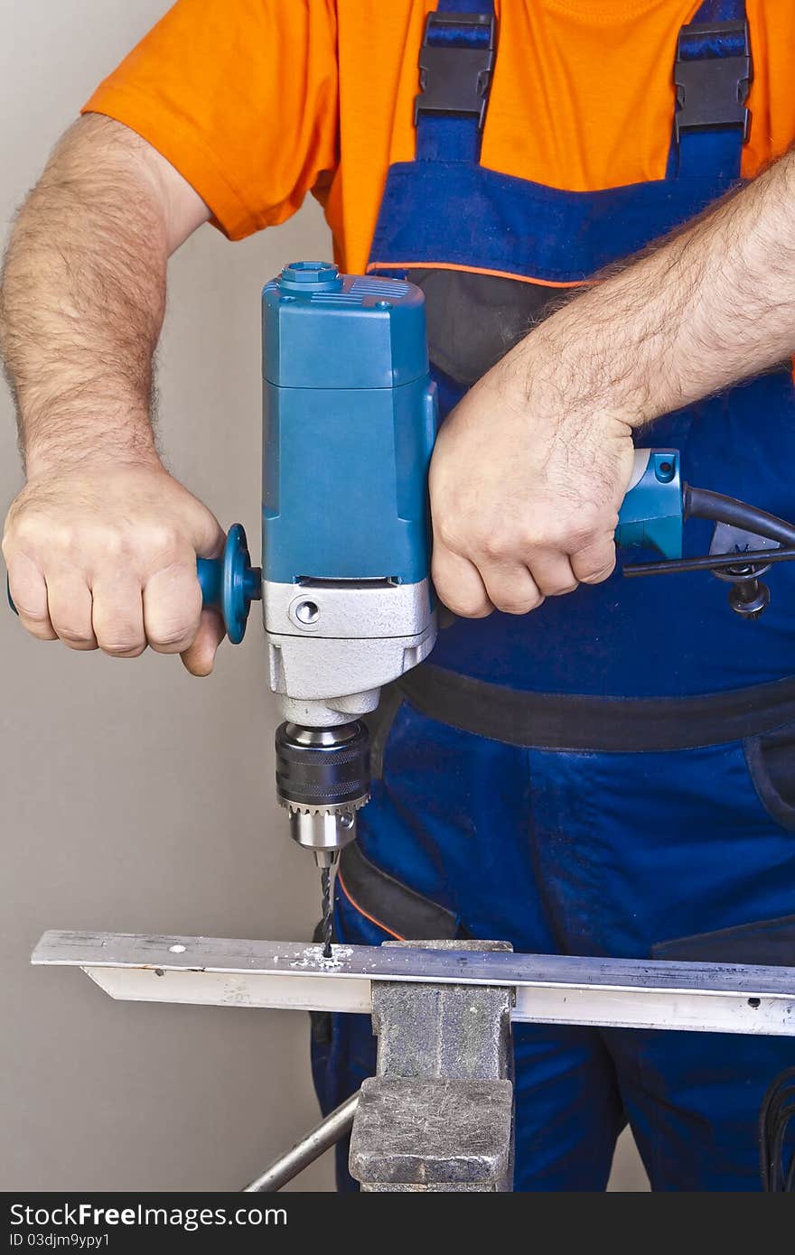 A man drilling a hole in the wall. A man drilling a hole in the wall.