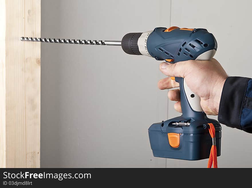 A man drilling a hole in wooden block. A man drilling a hole in wooden block