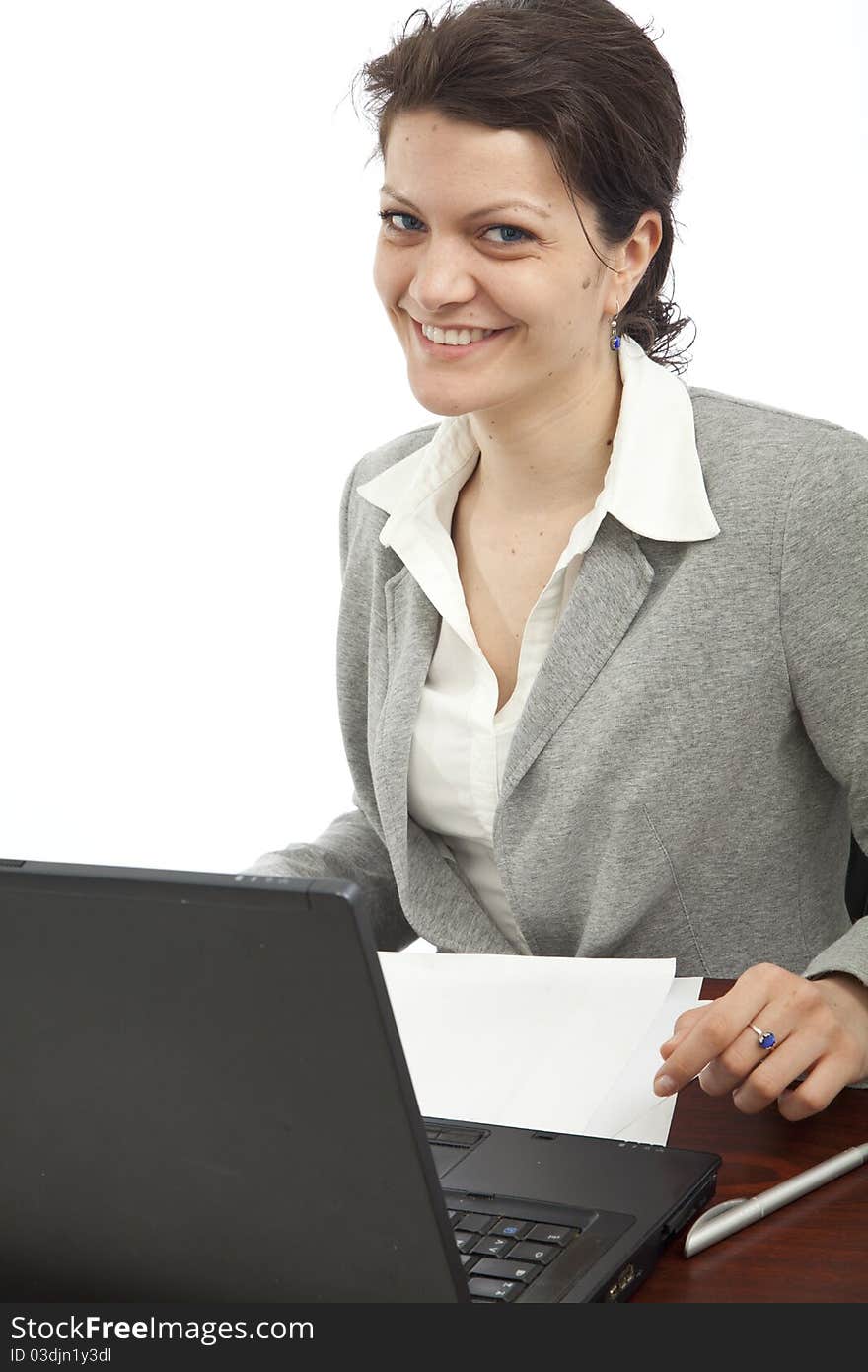 Smiling businesswoman on her office desk, portrait orientation