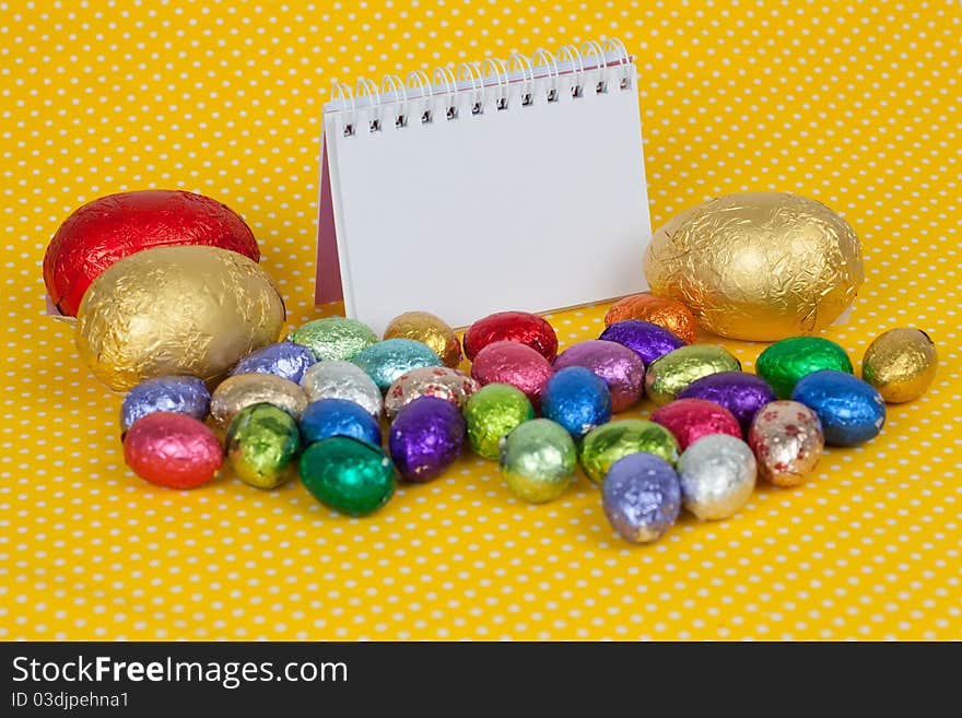 Blank notebook with Easter chocolate eggs.