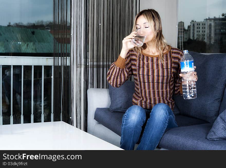 Blond woman drinking a glass of water. Blond woman drinking a glass of water