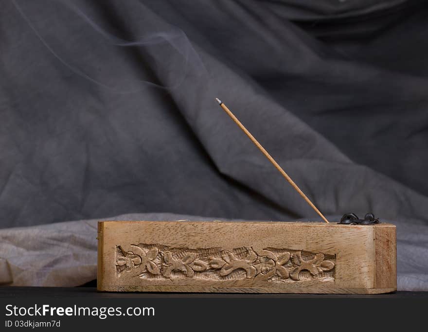 Carved wooden incense burner against dark background. Carved wooden incense burner against dark background.