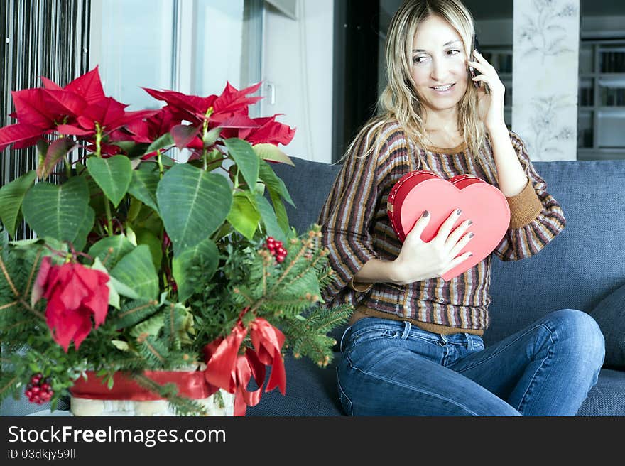 Happy blond woman thanking her boyfriend on the phone for a valentine's gift. Happy blond woman thanking her boyfriend on the phone for a valentine's gift