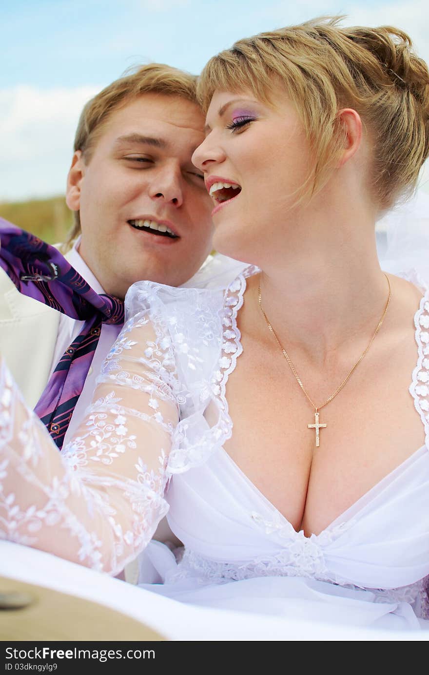 Bride and groom fooling with funny expressions outside