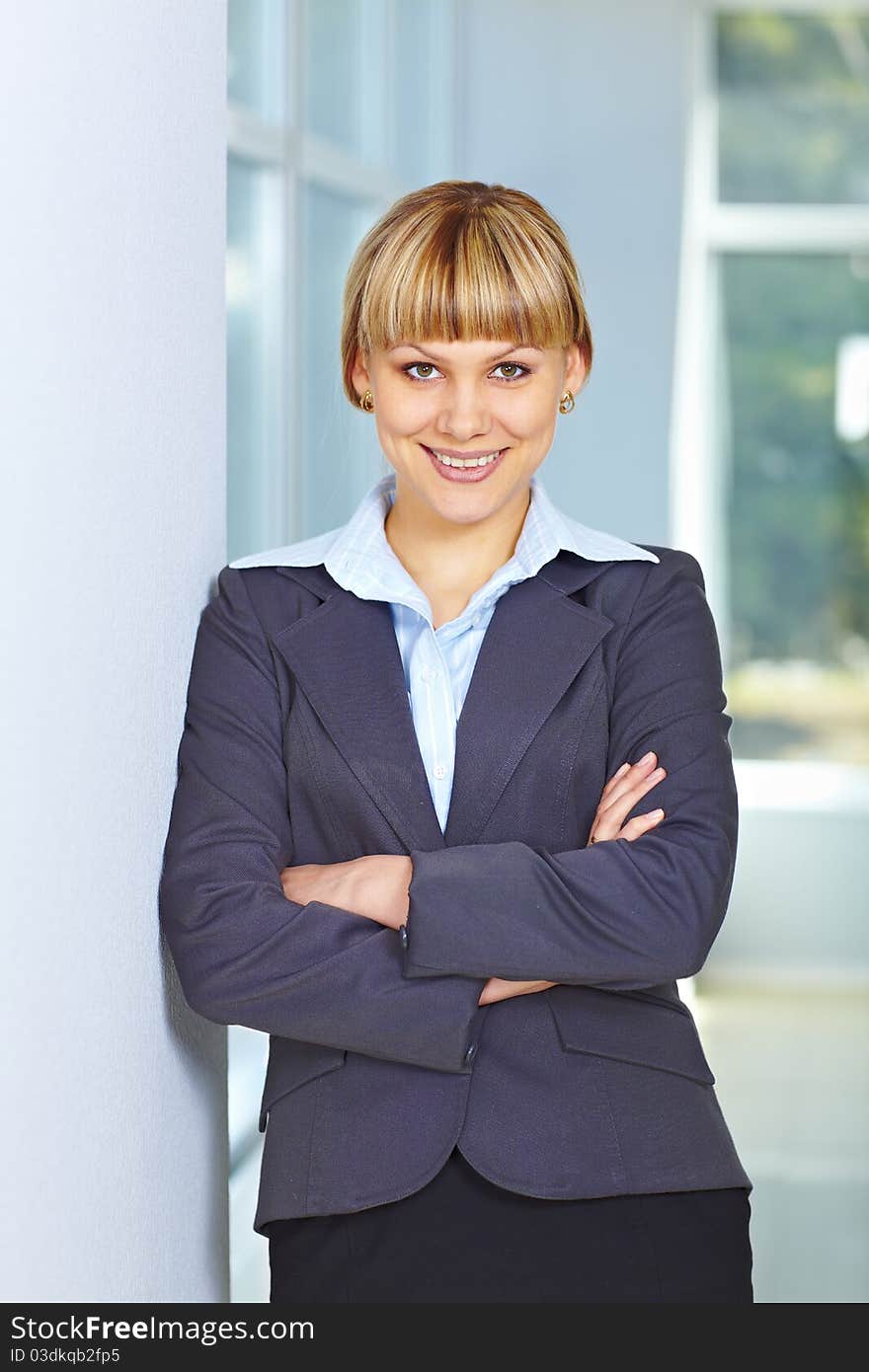 Young happy business woman standing casually with hands folded. Young happy business woman standing casually with hands folded