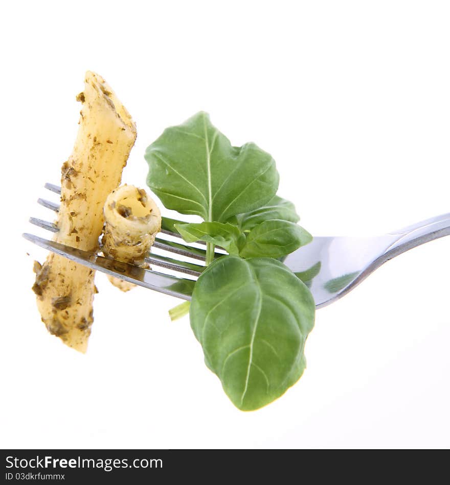 Penne with pesto on a fork