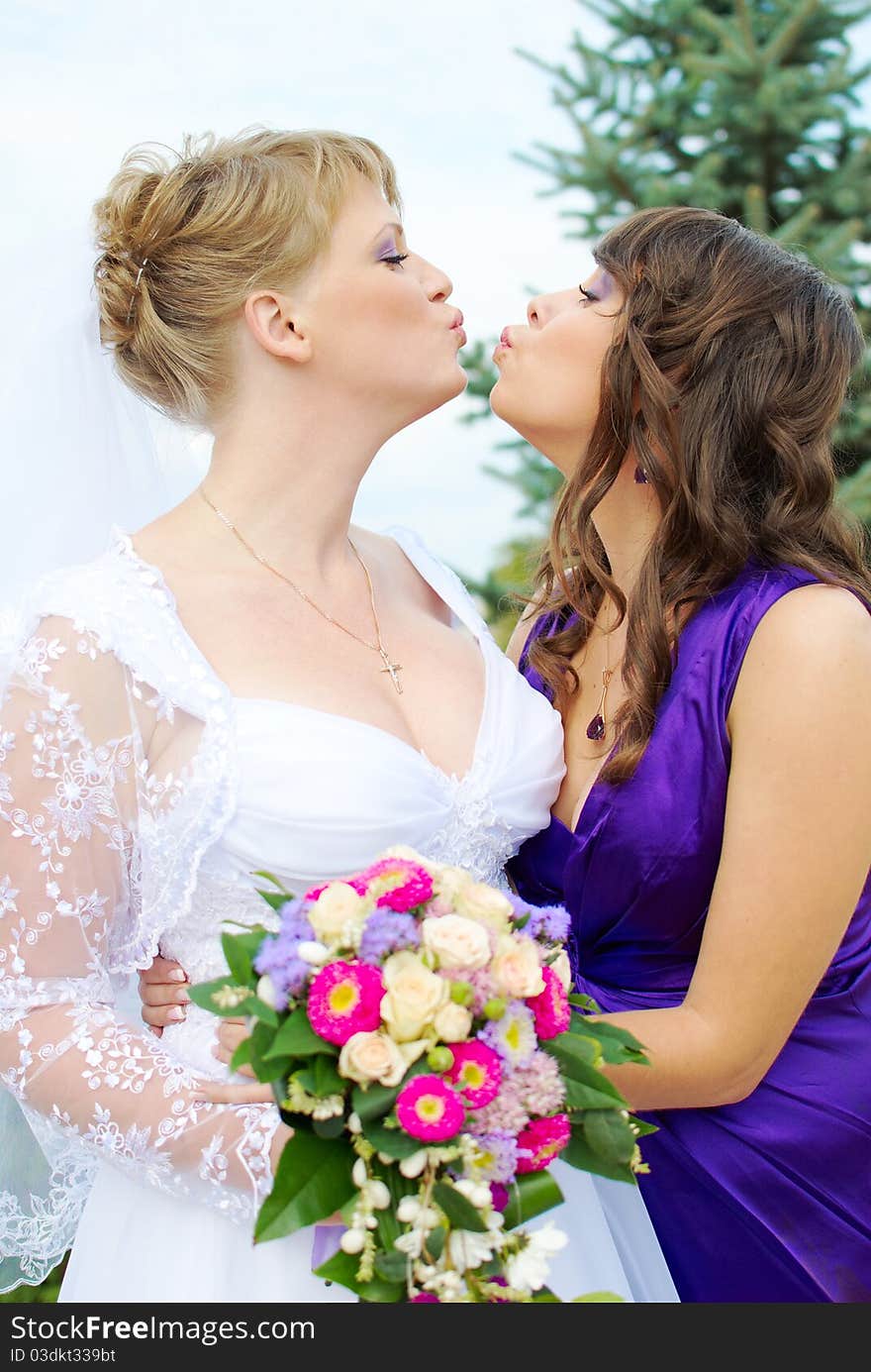 Bride and bridesmaid kissing