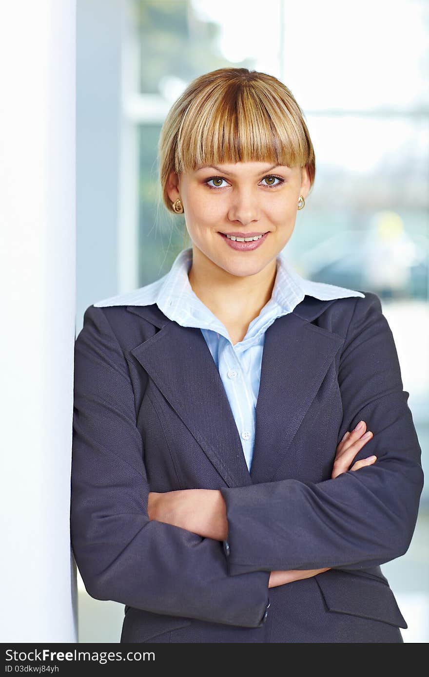 Young happy business woman standing casually with hands folded. Young happy business woman standing casually with hands folded