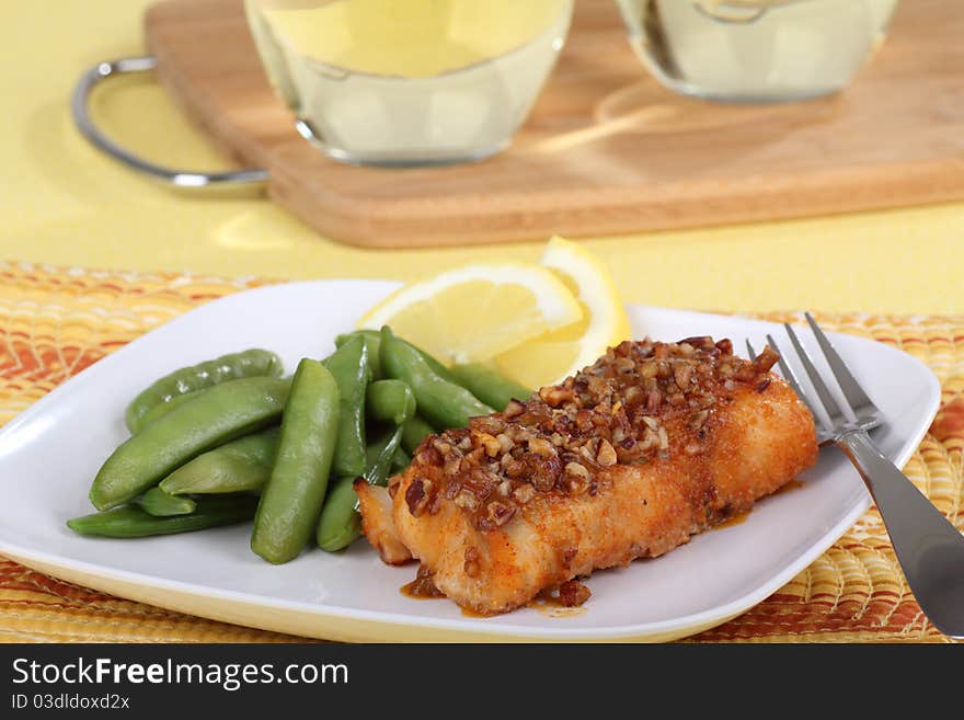 Fried cod fish fillet with snap peas and lemon slice. Fried cod fish fillet with snap peas and lemon slice