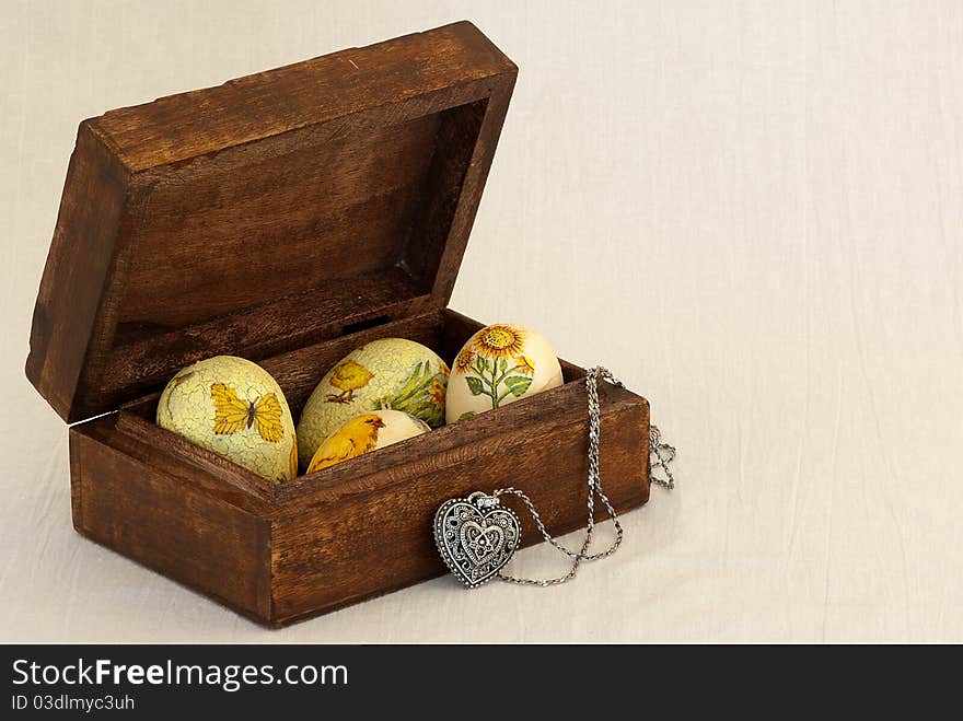 Easter eggs in a box with a silver heart. Easter eggs in a box for jewelry with a silver heart-shaped pendant. Eggs are clad with commemorative Easter samples of chickens, sunflowers, flowers . Easter eggs in a box with a silver heart. Easter eggs in a box for jewelry with a silver heart-shaped pendant. Eggs are clad with commemorative Easter samples of chickens, sunflowers, flowers ...