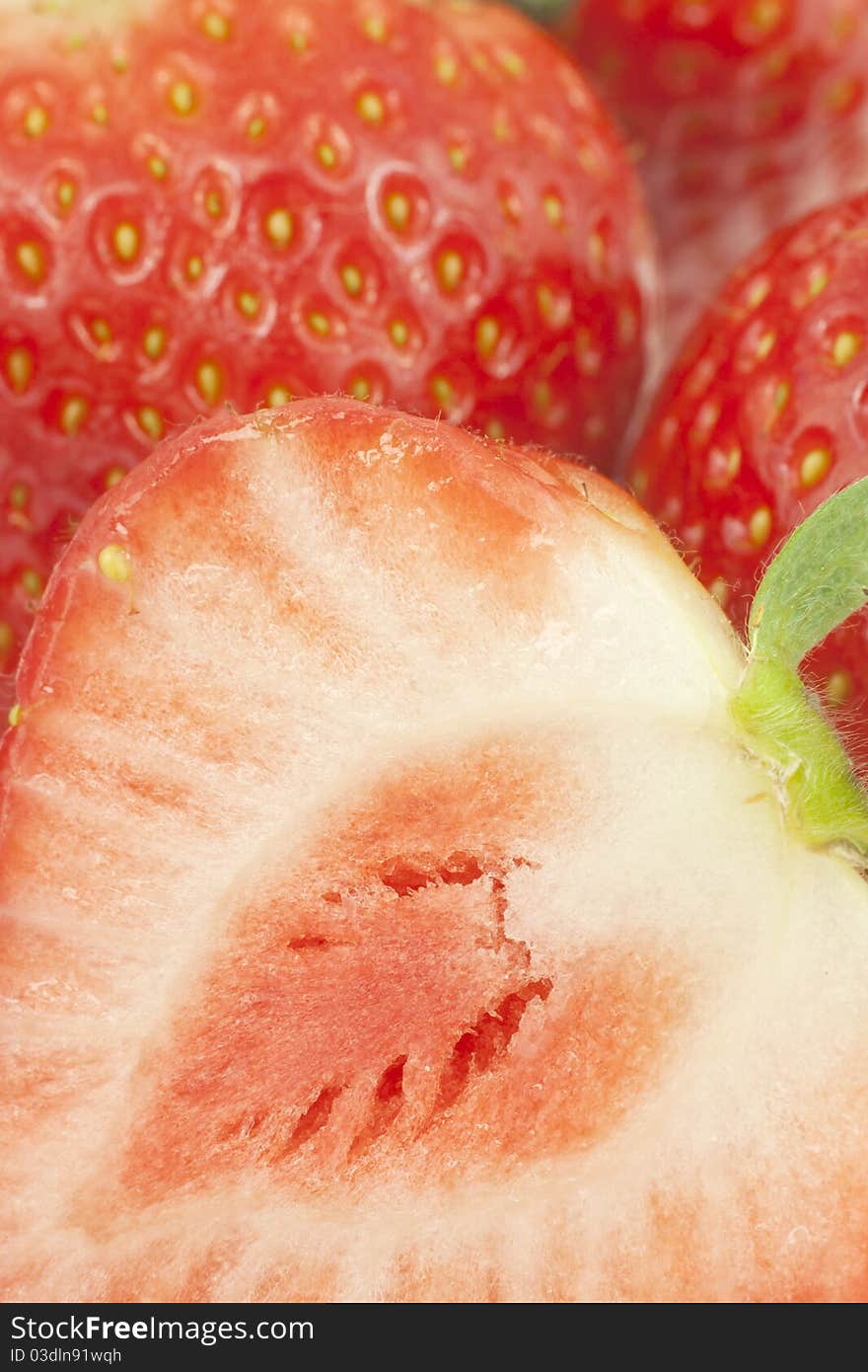 Close-up of cut strawberry with the others in the background, using shallow depth of field. Close-up of cut strawberry with the others in the background, using shallow depth of field.