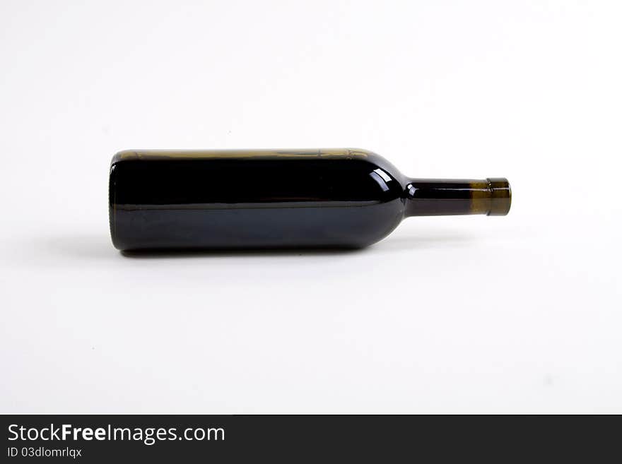 Close-up of red wine bottle over white