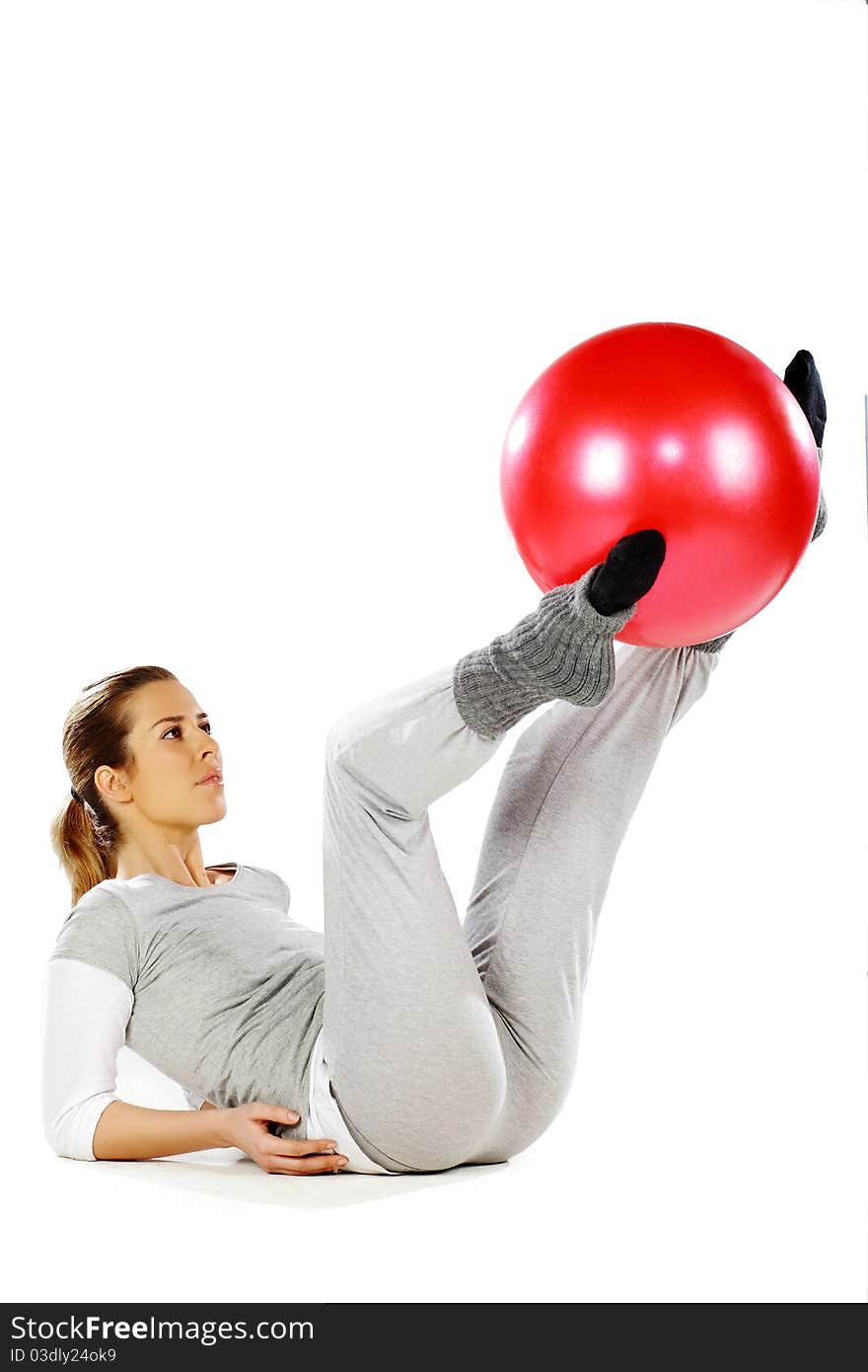 Girl exercising with a red ball between her legs