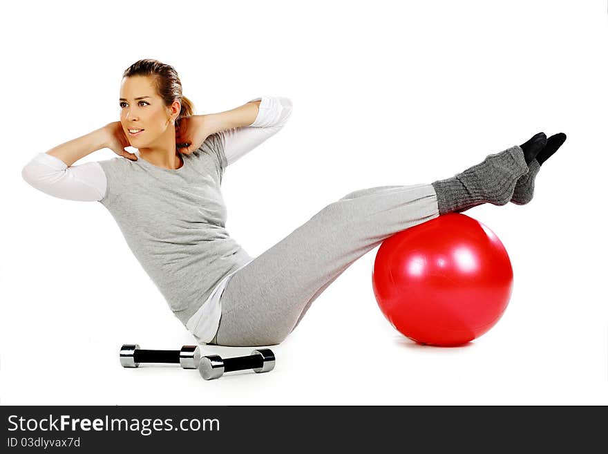 Girl sitting and exercising with a red ball