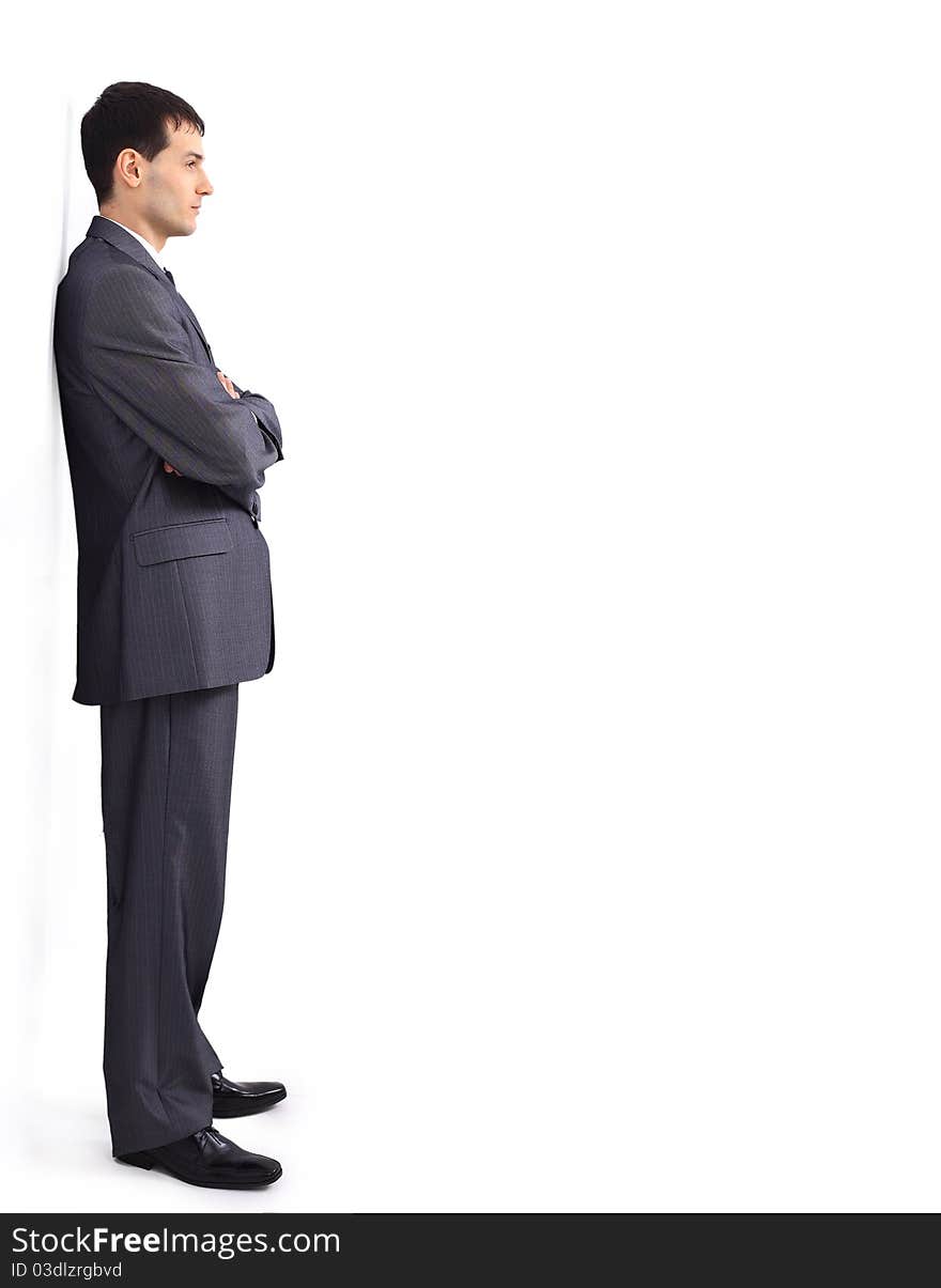 Cheerful young businessman leaning against wall. Cheerful young businessman leaning against wall