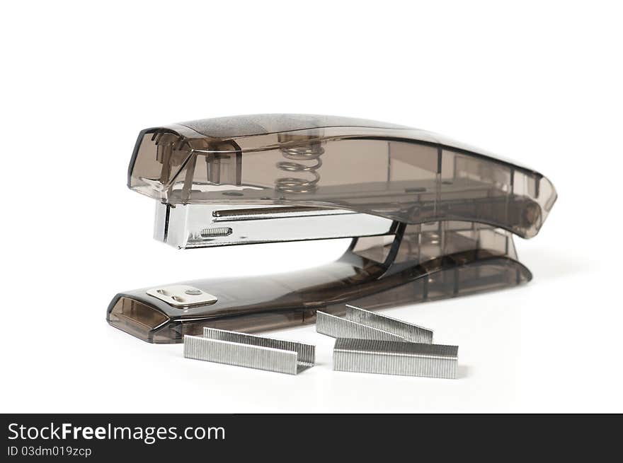 Transparent grey office stapler and staples isolated on white