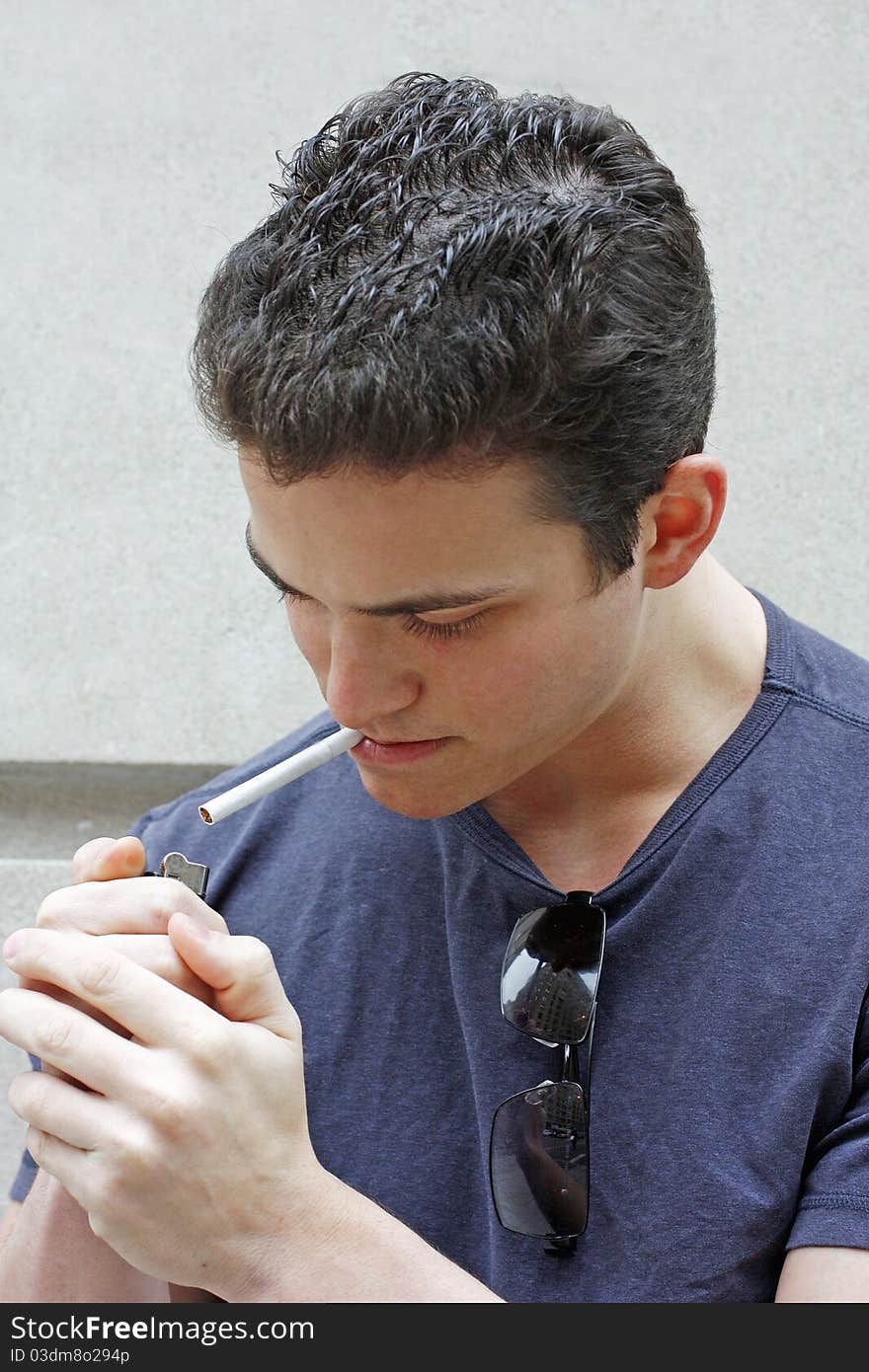 This is an image of a young man lighying up a cigarette. This is an image of a young man lighying up a cigarette.