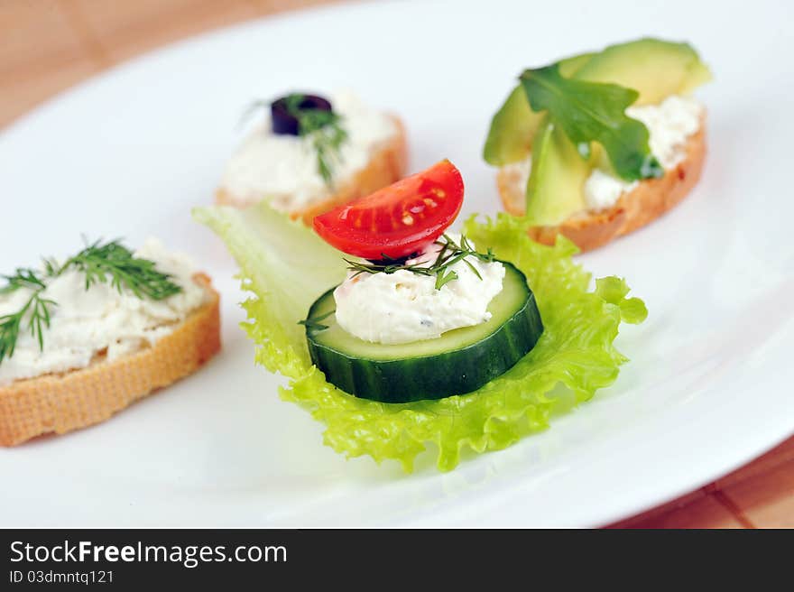 Tasty small sandwich from vegetables and cheese on dish