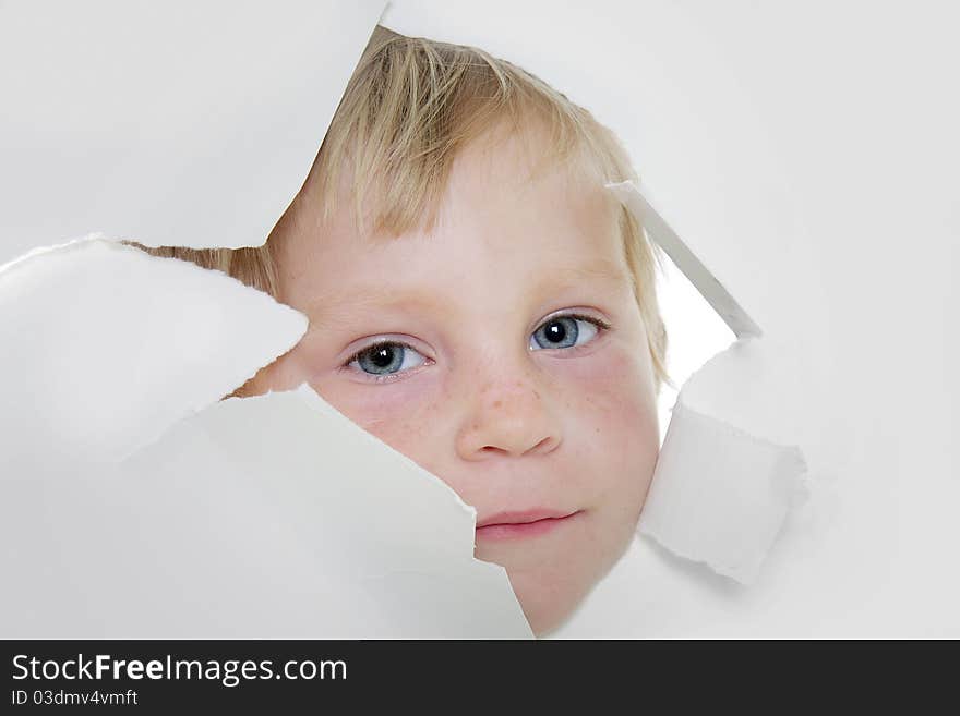 Cute child looking out from hole in paper