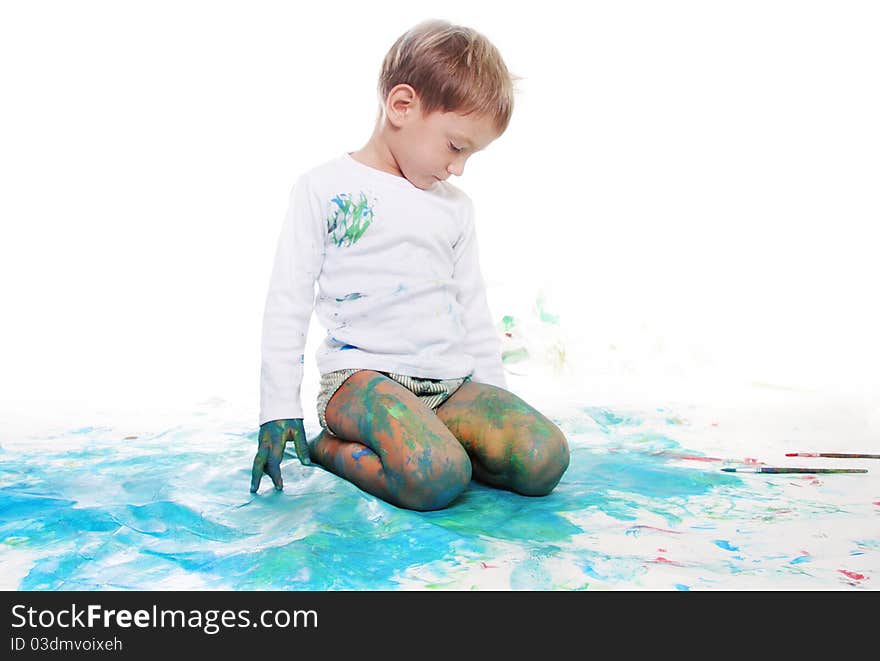 Young boy painting over white