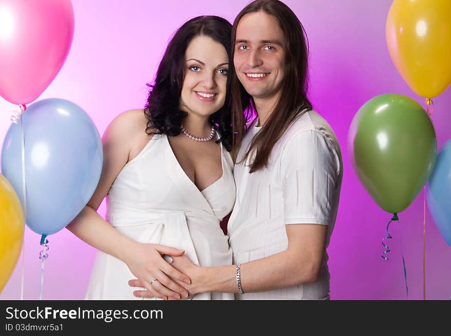 Happy young pregnant couple posing in studio. Happy young pregnant couple posing in studio