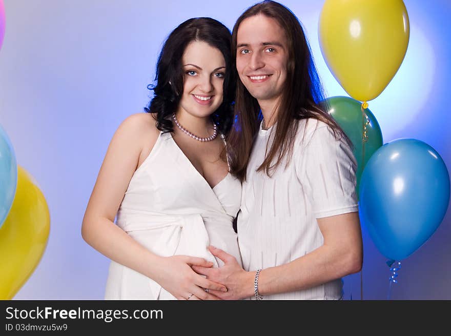 Happy young pregnant couple posing in studio. Happy young pregnant couple posing in studio