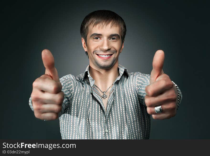 Young happy man going thumbs up