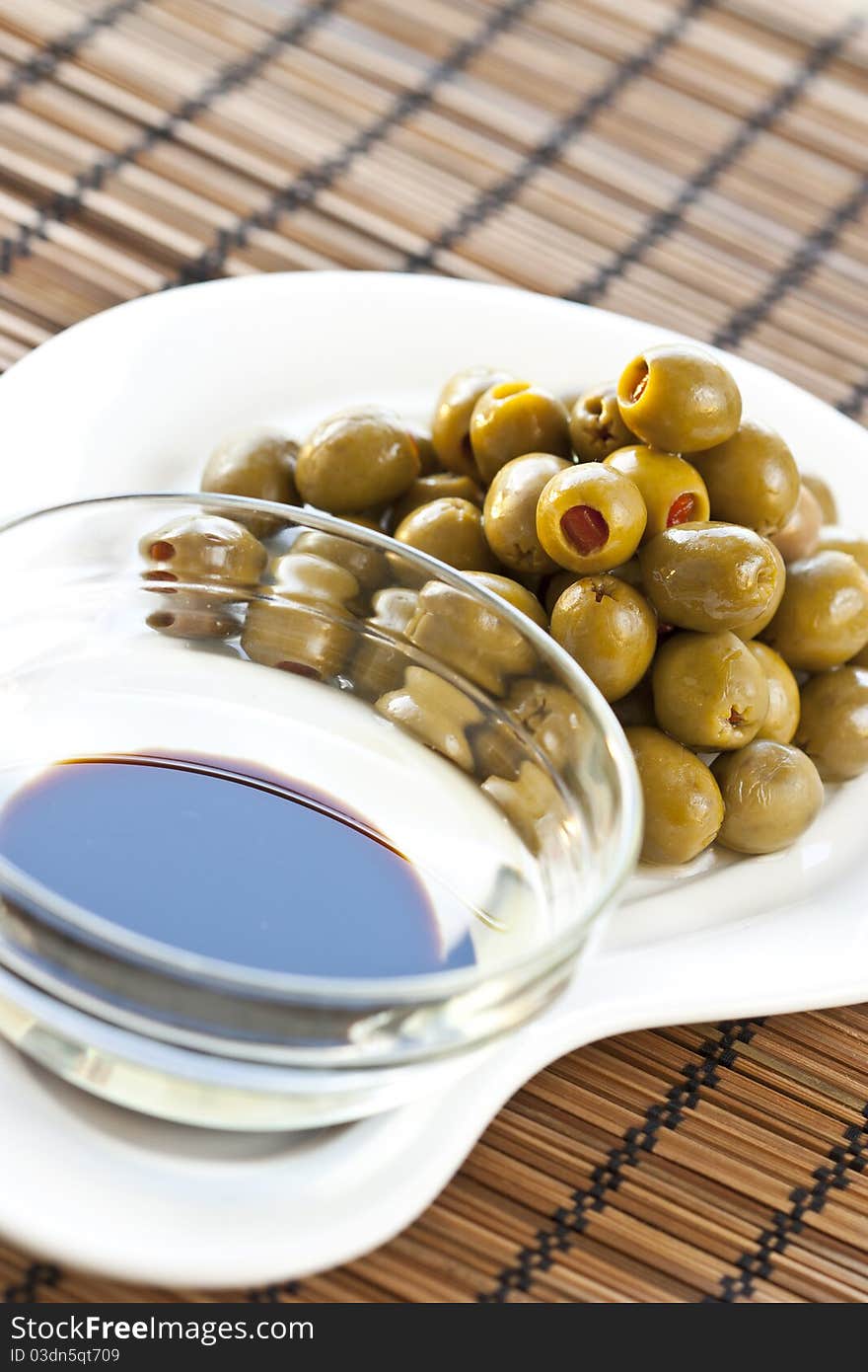 This is a heap of olives and oliveoil on a nice plate. This is a heap of olives and oliveoil on a nice plate