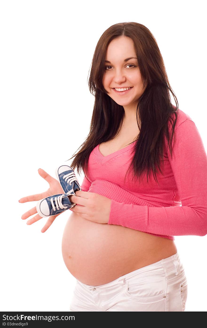 A pregnant woman holding baby shoes