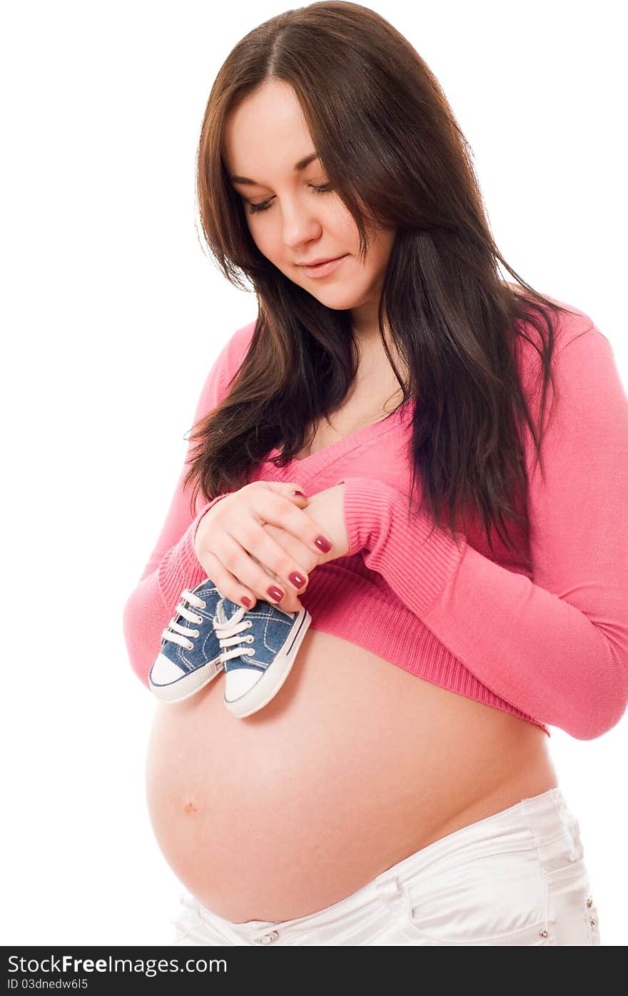 A pregnant woman holding baby shoes