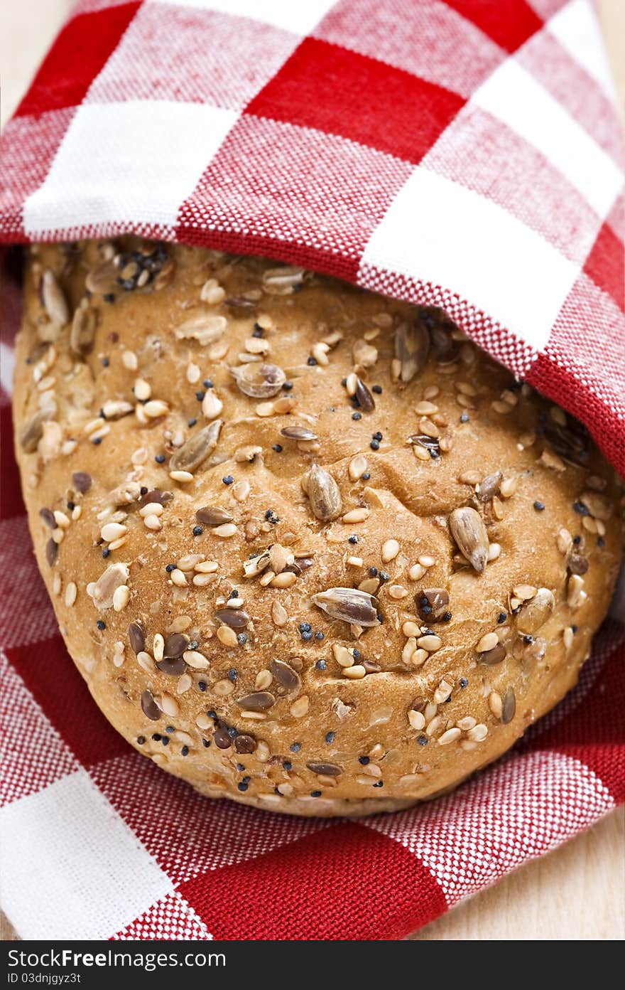 Whole wheat loaf in a red and white cloth ready to be served