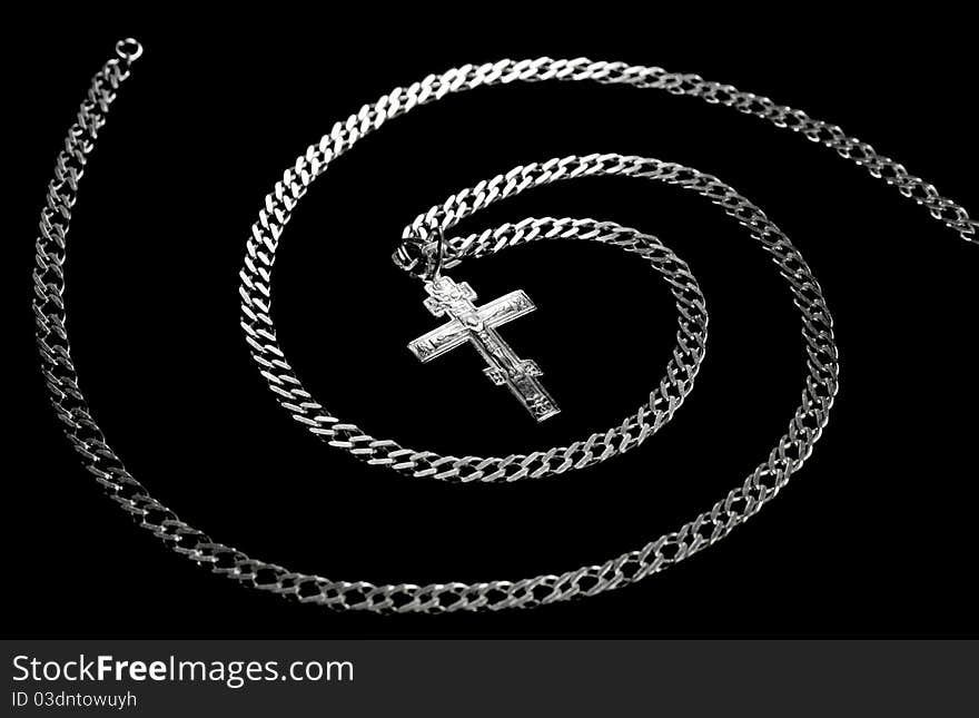 Chain and cross combined in a spiral isolated on a black background