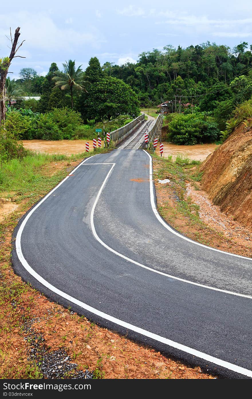 Road with bridge over a brown river