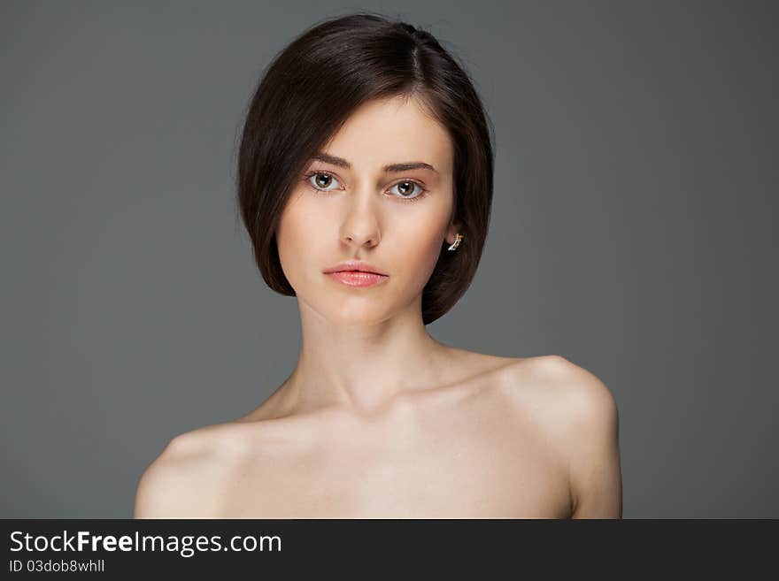 Close-up young beautiful woman on a grey background